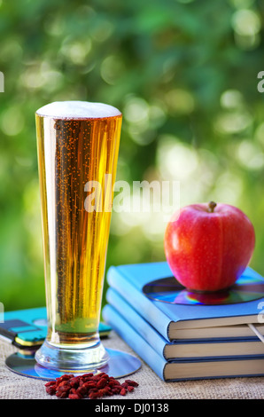 Bière froide et Apple sur les livres Banque D'Images