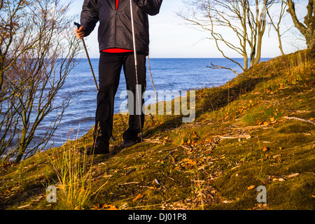 Pieds de l'homme de cultiver la marche nordique sur la plage Banque D'Images