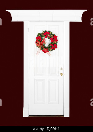 Couronne de fleurs de noël accroché sur la porte de bois blanc avec cadre décoratif, rouge foncé plus isolés Banque D'Images