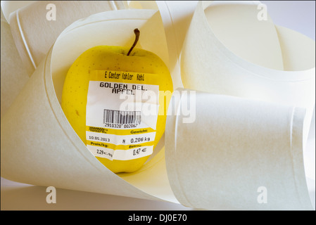 Une pomme Golden Delicious allemand avec code-barre montrant le poids et prix en euro entre les rouleaux de papier Banque D'Images