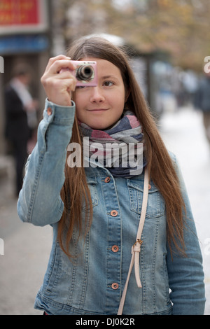 Jeune fille à prendre des photos dans la rue de Prague. Banque D'Images