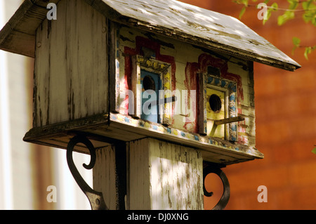 Maison d'oiseau assis sur un poste à l'extérieur d'une maison. Banque D'Images