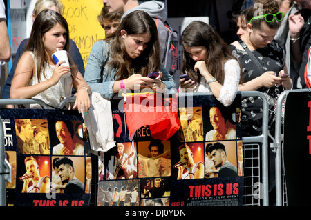 London Premiere d 'un sens - c'est nous' à Leicester Square, le 20 août 2013. Les filles texting Banque D'Images