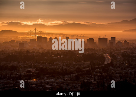 Vue du centre-ville d'Oakland, Californie et le pont de la baie de port au coucher du soleil Banque D'Images