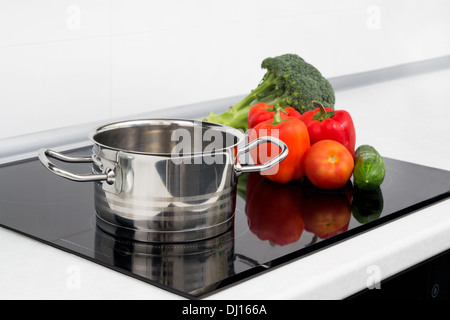 Pot et des légumes dans une cuisine moderne avec cuisinière à induction Banque D'Images