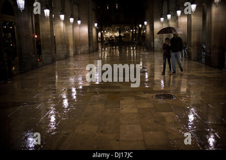 Quartier Gothique de Barcelone, Espagne 18 novembre, 2013.Un couple s'abriter sous un parapluie dans la rue menant de la Rambla à la Place Real à Barcelone. La pluie persistante sur Barcelone après des mois sans pluie. Crédit : Jordi Boixareu/Alamy Live News Banque D'Images