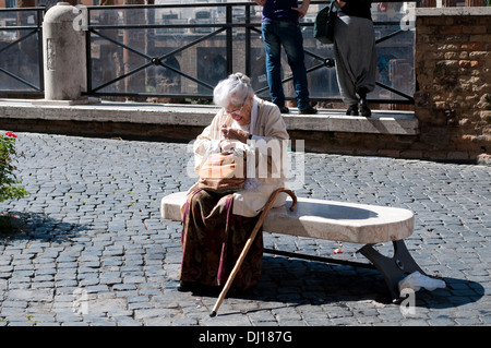 Vieille dame avec un énorme key assis sur un banc de Square Largo di Torre Argentina, Campus Martius, Rome, Italie Banque D'Images