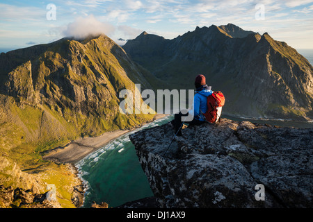 Female hiker enjoying view de Kvalvika plage depuis près de sommet de Ryten, Moskenesoy, îles Lofoten, Norvège Banque D'Images