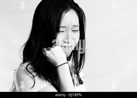 Portrait de jeune femme pleurer tout en tirant sur ses cheveux, style noir et blanc Banque D'Images