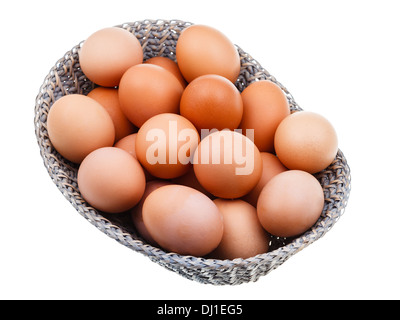 Les oeufs de poulet frais dans panier en osier isolé sur fond blanc Banque D'Images