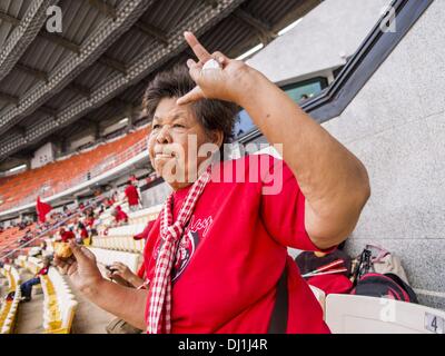 Bangkok, Thaïlande. 19 nov., 2013. Un chandail rouge partisan de danses country music thaïlandais au cours d'une chemise rouge rassemblement à Bangkok. Jusqu'à 30 000 ''Red Shirts'' sont attendus à Bangkok cette semaine à l'avance d'une décision de la cour thaïlandaise qui pouvait provoquer l'effondrement du gouvernement de Yingluck Shinawatra, le premier ministre. Les chemises rouges sont réunis dans un stade de banlieue avant de marcher à la cour. Les chemises rouges sont pour la plupart des agriculteurs et ruraux thaïlandais qui appuient le gouvernement Shinawatra. Crédit : Jack Kurtz/ZUMAPRESS.com/Alamy Live News Banque D'Images