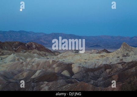 Pleine lune à l'aube sur la Panamint Range et la vallée de la mort. Vu de Zabriskie Point avec les badlands de Gower Gulch dans th Banque D'Images