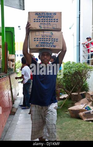 Ormoc, Philippines. 18 novembre 2013. Un bénévole fournit des approvisionnements de secours à la suite du super typhon Haiyan, 18 novembre 2013 à Ormoc, Philippines. Credit : Planetpix/Alamy Live News Banque D'Images