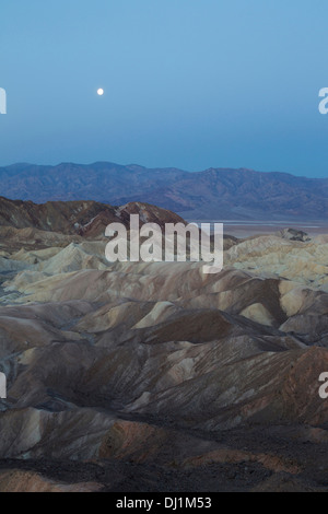 , Pleine lune à l'aube sur la Panamint Range et la vallée de la mort. Vu de Zabriskie Point avec les badlands de Gower Gulch dans Banque D'Images