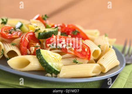 Plat de pâtes penne végétarienne courgettes cuites au four avec tomates et épicé avec le thym et l'ail Banque D'Images