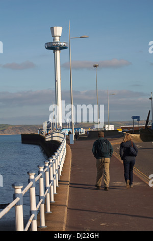 Couple en train de marcher vers la jetée et Sealife Tower, Jurassic Tour Horizon, à Weymouth en Novembre Banque D'Images