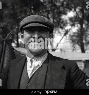 Tableau historique des années 1950. Portrait of a smiling et fier petit agriculteur debout sur sa terre, Norfolk, Angleterre. Banque D'Images