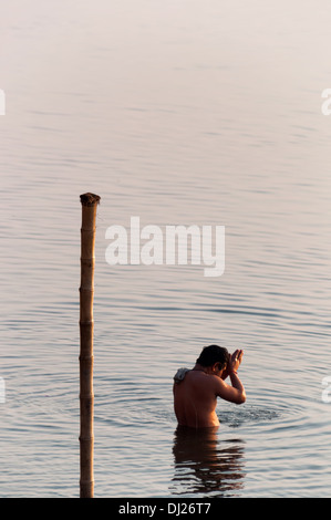 VARANASI 18 février 2012 : l'homme hindou en priant Gange au lever du soleil. Banque D'Images