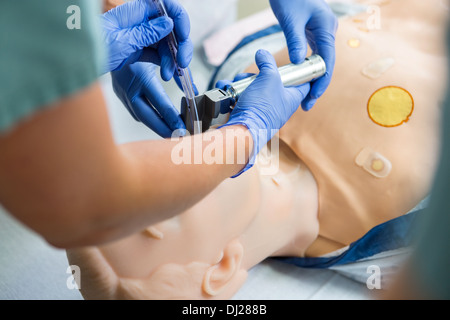 L'équipe médicale dans le tube de réglage de la bouche du patient factice Banque D'Images