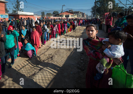 Katmandou, Katmandou, Népal. 19 nov., 2013. Une jeune fille tient son frère pendant que ses parents la queue pour exprimer leur vote crédit : Agron Dragaj/ZUMAPRESS.com/Alamy Live News Banque D'Images