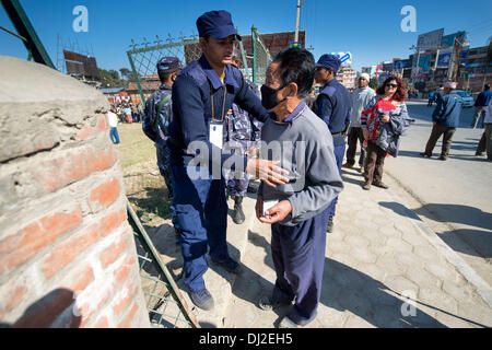 Katmandou, Katmandou, Népal. 19 nov., 2013. Le personnel de sécurité de l'électeur chèques avant d'entrer dans le bureau de vote : Crédit Agron Dragaj/ZUMAPRESS.com/Alamy Live News Banque D'Images