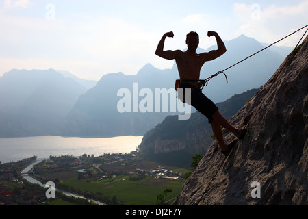 Silhouette d'un alpiniste flexing biceps contre vue pittoresque sur le lac de Garde, Arco, Italie du nord Banque D'Images