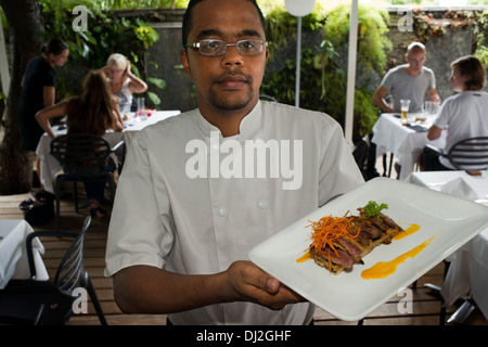 Atelin Ives, chef du Restaurant Villa Marie à Saint Denis. Villa angélique, offre le déjeuner, de type de cuisine 'bar'. Une carte hebdomadaire tentant et fabuleux buffet de desserts, servis sur la terrasse, entourée d'un jardin d'orchidées lontan la végétation et les parois cellulaires végétales endémiques. Un moment de sweet escape en plein coeur de la ville ... Dans la soirée, nous vous accueille dans un cadre élégant et confortable avec une carte raffinée, combinant tradition et modernité. Villa Angélique et l'équipe de collègues qui enchantent avec leur nourriture et leur passion, nous vous invitons à découvrir. Banque D'Images