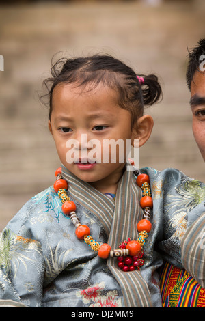 Le Bhoutan, Thimphu Dzong, Tsechu annuel, traditionnellement vêtus jeune fille dans les bras du père Banque D'Images