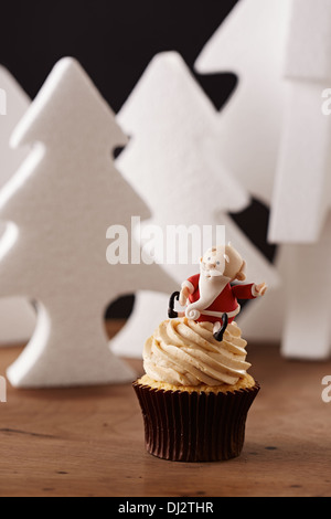 Santa Claus cupcake sur fond d'arbres de Noël blanc Banque D'Images