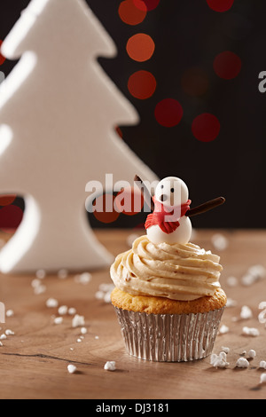 Le Snowman cupcake blanc sur fond d'arbre de Noël Banque D'Images