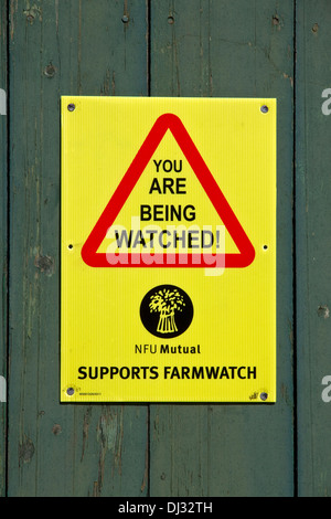 'Avis' Farmwatch ( pour décourager les vols) sur les portes en bois de grange en pierre rural, Stonyhurst, vallée de Ribble, Lancashire, England, UK Banque D'Images