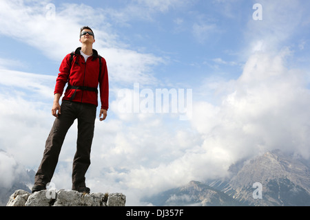 Jeune alpiniste debout sur le sommet d'une montagne et jouissant de la liberté dans les montagnes Banque D'Images