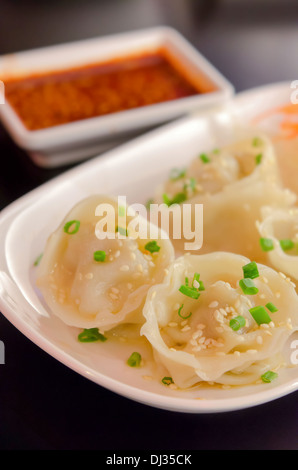 Mandu Coréen , Quenelles , Porc Gyoza bouillis avec sauce chili Banque D'Images