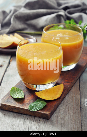 Smoothie mangue dans verre à la menthe sur fond de bois Banque D'Images