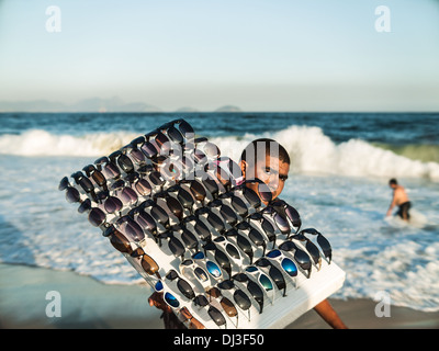 Un commerçant lunettes de plage sur la plage de Copacabana à Rio de Janeiro, Brésil. Banque D'Images