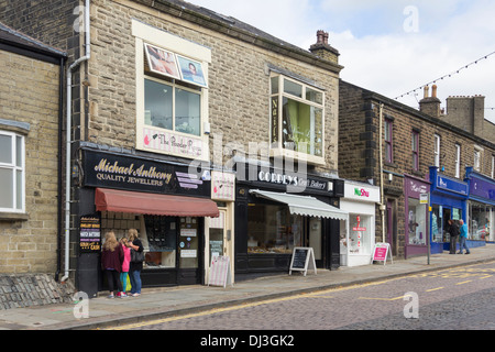 Petits commerces locaux et d'entreprises familiales sur la rue Bank, dans le centre-ville de Rawtenstall, Lancashire avec un peu de shopping. Banque D'Images