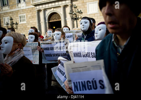 Barcelone, Espagne. 21 novembre, 2013. 24 novembre prochain est la Journée internationale des sans-abri. Dans le cadre de la campagne 'Personne ne sans la santé. Personne ne sans maison" promu par diverses organisations sociales a accompli un acte de protestation à Barcelone où plusieurs personnes masquées, des militants et des sans-abri, ont affiché des banderoles exigeant et santé accueil pour tout le monde. En Espagne, la crise économique a accru le nombre de personnes qui sont sans abri et dans le besoin de soutien social. Crédit : Jordi Boixareu/Alamy Live News Banque D'Images