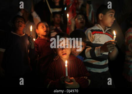 Gaza, territoire palestinien. 21 nov., 2013. Les enfants palestiniens crier des slogans pour résoudre la crise électrique de Gaza alors qu'ils détiennent des bougies et des bannières au cours d'une manifestation organisée par le Front démocratique pour la libération de la Palestine (FDLP) devant le siège social de la société d'électricité dans la bande de Gaza le 21 novembre 2013. Credit : ZUMA Press, Inc./Alamy Live News Banque D'Images