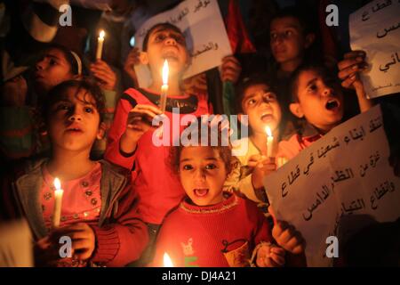 Gaza, territoire palestinien. 21 nov., 2013. Les enfants palestiniens crier des slogans pour résoudre la crise électrique de Gaza alors qu'ils détiennent des bougies et des bannières au cours d'une manifestation organisée par le Front démocratique pour la libération de la Palestine (FDLP) devant le siège social de la société d'électricité dans la bande de Gaza le 21 novembre 2013. Credit : ZUMA Press, Inc./Alamy Live News Banque D'Images