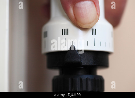 La main de l'homme le réglage d'une vanne thermostatique sur un radiateur à la maison. Banque D'Images