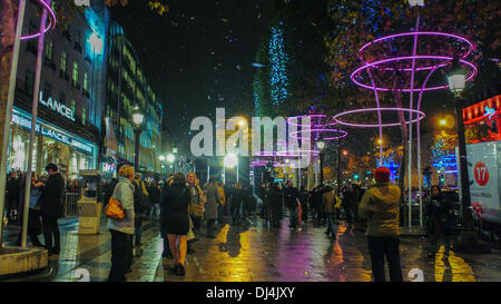 Paris, France, foule animée de personnes Marche Noël lampe de rue LED Eclairage écologique Décorations sur l'avenue des champs-Élysées, pluie la nuit, Paris rue animée scène centre de rue, lumières énergie durable Banque D'Images