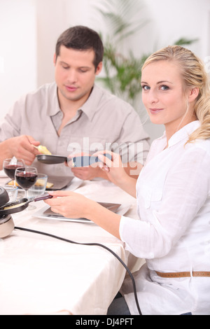 Couple eating un appareil à raclette Banque D'Images