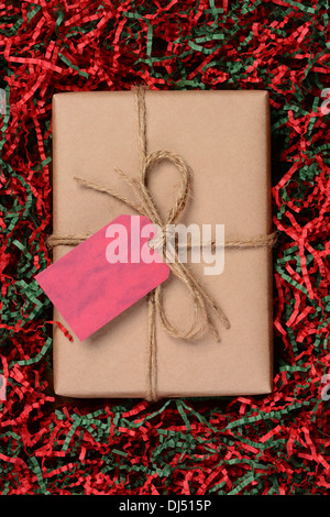 Vue aérienne d'un seul cadeau de Noël emballés avec du papier craft eco friendly et attachées avec de la ficelle. Banque D'Images