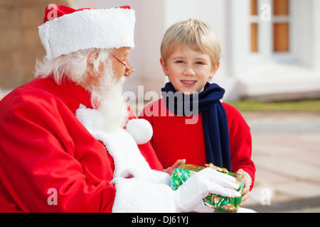 Garçon en tenant présent du Père Noël Banque D'Images