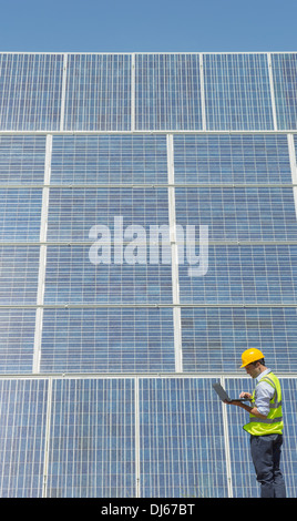 L'examen des travailleurs des panneaux solaires Banque D'Images