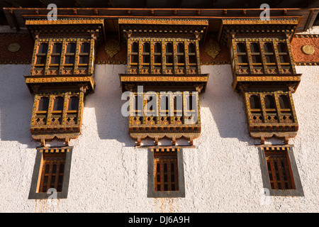 Le Bhoutan, Punakha Dzong, fenêtres en bois sculpté, avec décoration à motifs dans la lumière du soir Banque D'Images