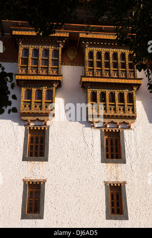 Le Bhoutan, Punakha Dzong, fenêtres en bois sculpté, avec décoration à motifs, dans la lumière chaude soirée Banque D'Images