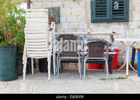 Vieux empilé des chaises en plastique et une table à l'arrière du café à Dubrovnik Banque D'Images