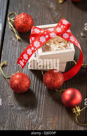 Boules de Noël rouge et une boîte en bois avec un arc Banque D'Images