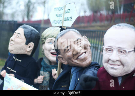 Varsovie, Pologne. 22 nov., 2013. Des manifestants portant des masques (L-R) Le Premier ministre japonais Shinzo Abe, la chancelière allemande, Angela Merkel, le président américain Barack Obama et le président français François Hollande, assister à une démonstration à l'extérieur du stade national au cours de la 2013 Conférence des Nations Unies sur le changement climatique à Varsovie, Pologne, 22 novembre 2013, appelant les dirigeants du monde à décider quelle route ils veulent prendre dans les négociations sur le climat. (Xinhua/Zhang Fan) Photo : Xinhua/Alamy Live News Banque D'Images